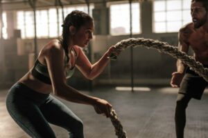 A young woman working out with battle ropes