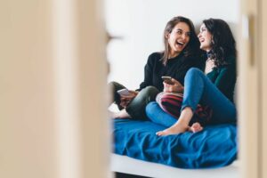 Two female friends sitting and laughing together
